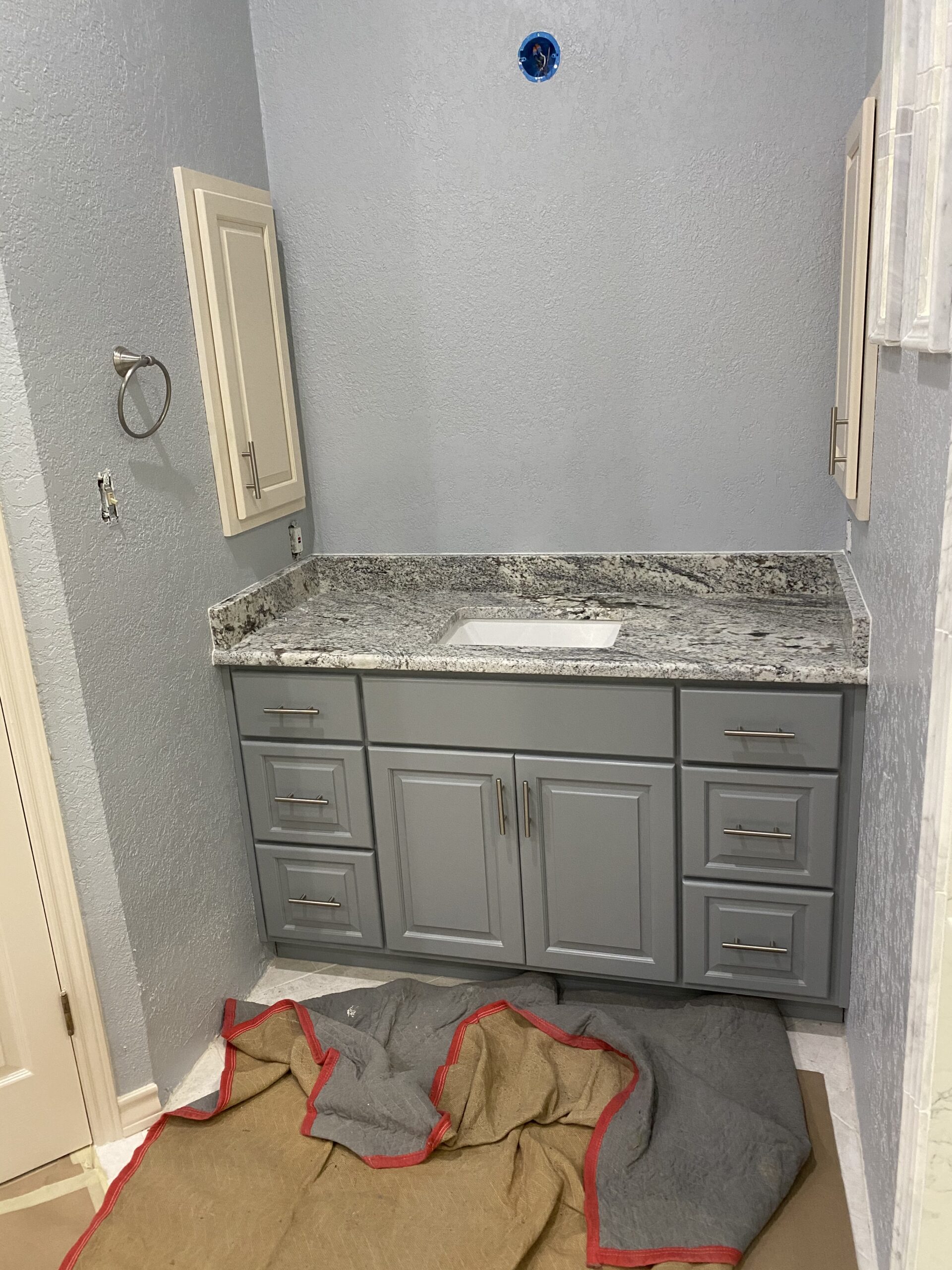 Cabinet expert aligning bathroom vanity doors with careful precision and finishing detail